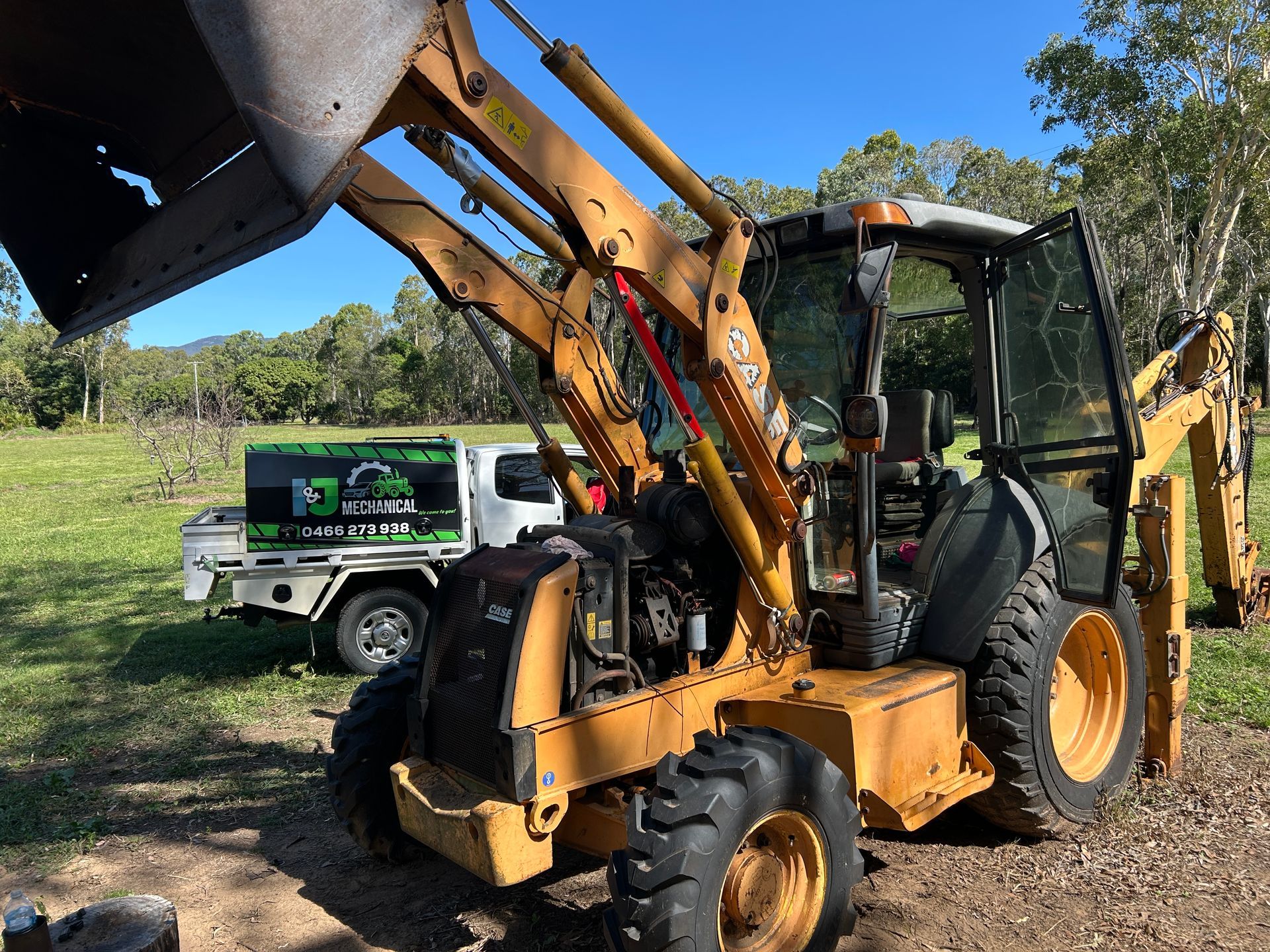 Work ute is Parked Next to a Yellow and Black machine — I & J Mechanical in Deeragun, QLD