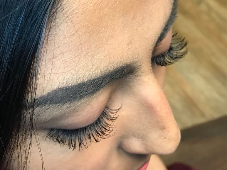 A close up of a woman 's eye with long eyelashes.