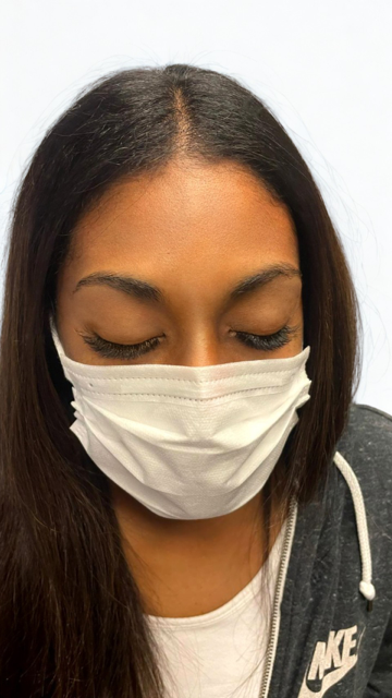 A woman wearing a mask and a nike hoodie