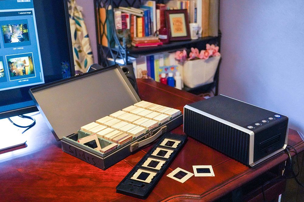 A desk with a computer and a box of slides on it