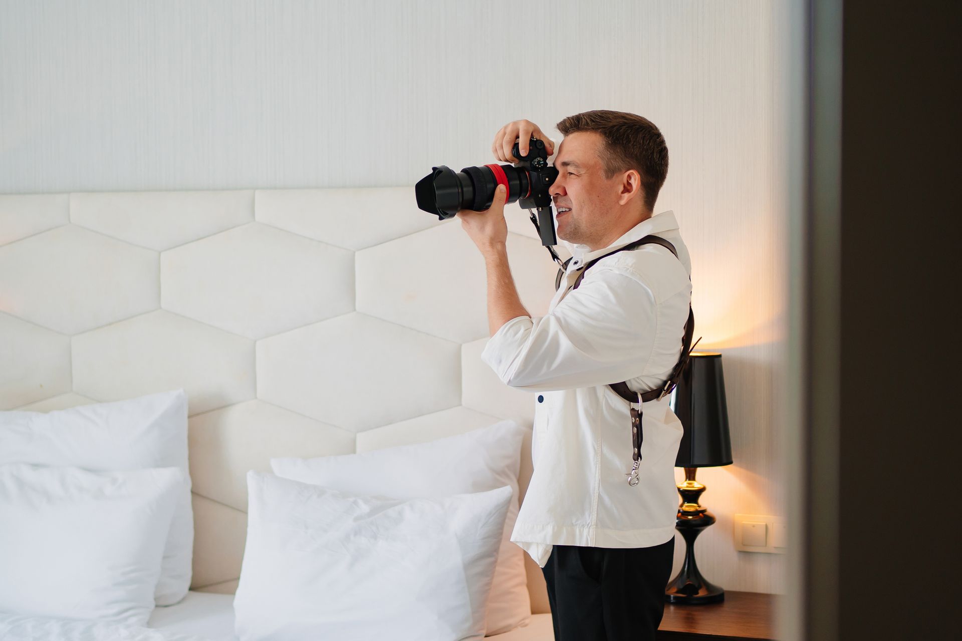 A male photographer takes a photo in a bedroom. A male photographer takes a photo in a bedroom.