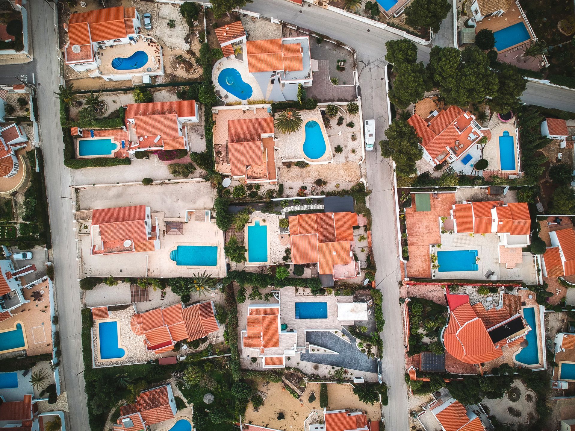A drone photographer is capturing an aerial view of a block of houses for real estate marketing.
