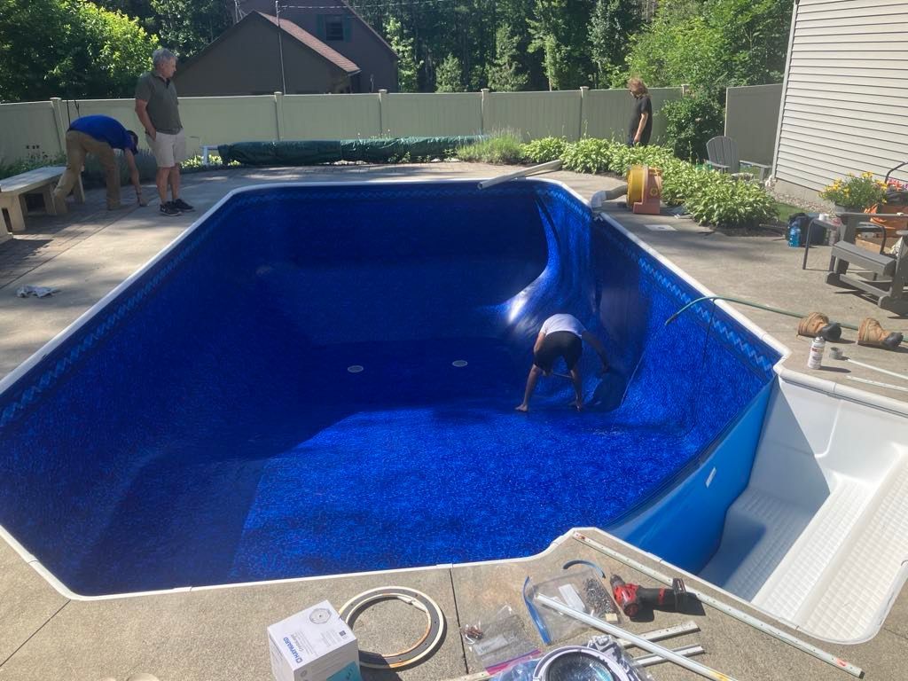 A man is working on the inside of a swimming pool.