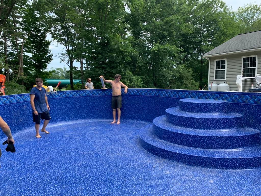 A group of people are standing in a swimming pool.