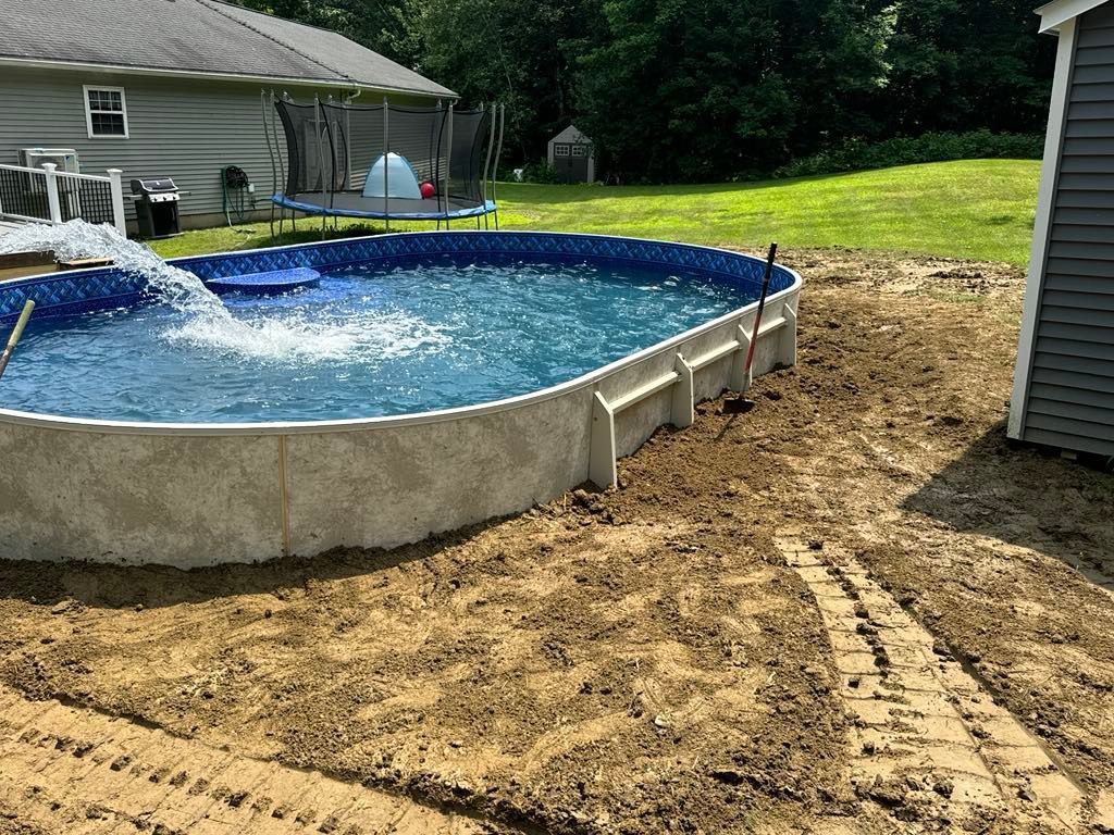 A large swimming pool is being built in a backyard.
