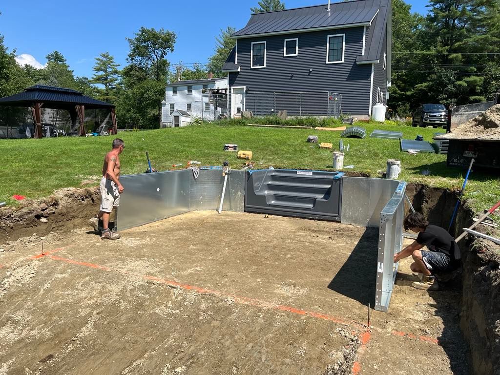 A man is working on a swimming pool in front of a house.
