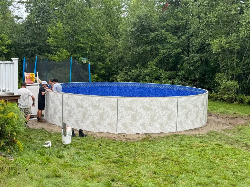 A group of people are working on a swimming pool in a backyard.