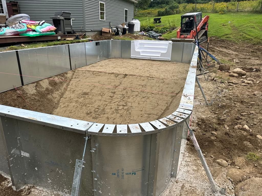 A swimming pool is being built in the backyard of a house.