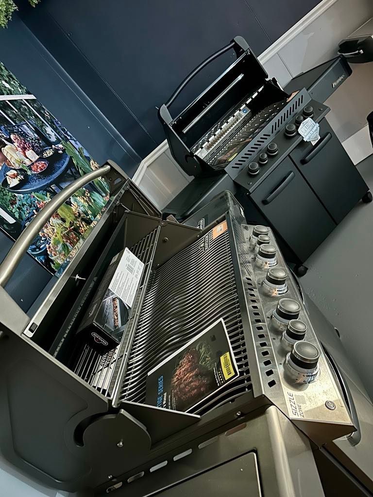A gas grill is sitting on top of a counter in a kitchen.
