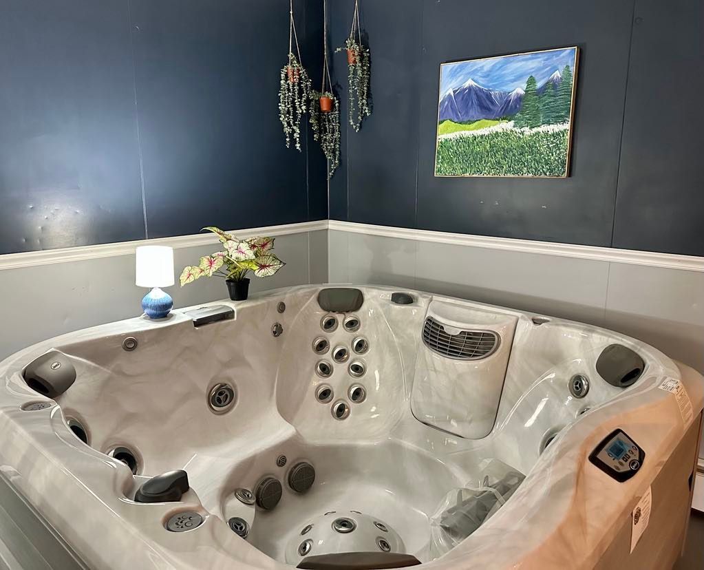 A white hot tub is sitting in a corner of a room next to a painting on the wall.