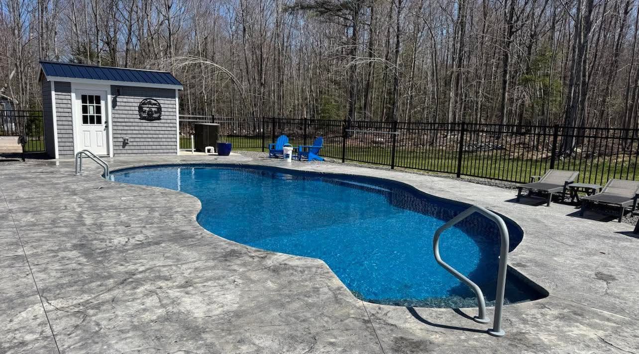 A large swimming pool with a shed in the background.