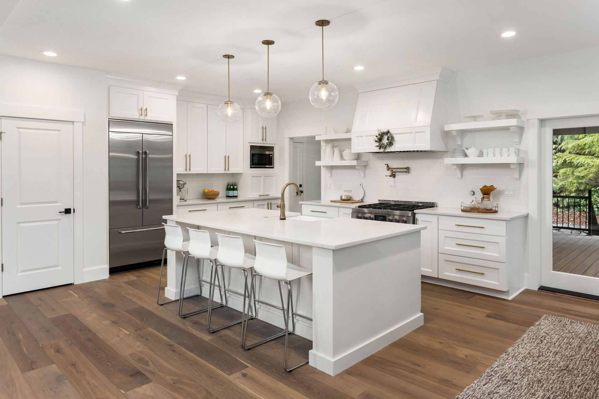 A kitchen with white cabinets and stainless steel appliances and a large island.