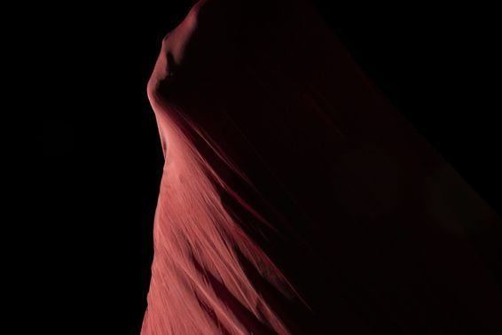 Dark red fabric draped against a black background.