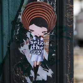 Street art sticker: cartoon girl with hypnotic hair, holding 