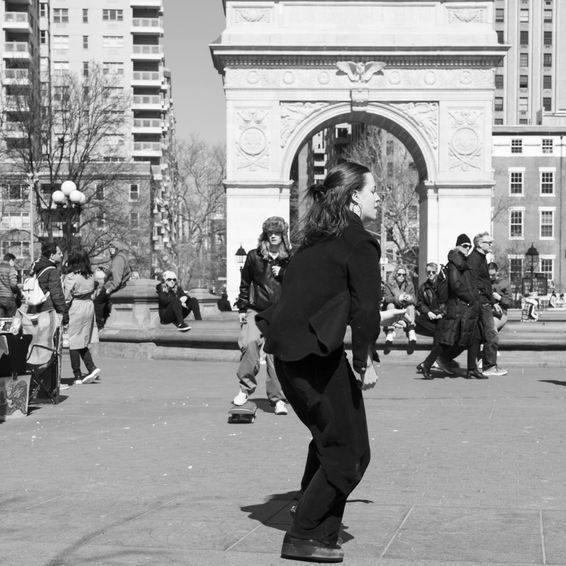 Woman skateboarding in front of Washington Square Arch, NYC.
