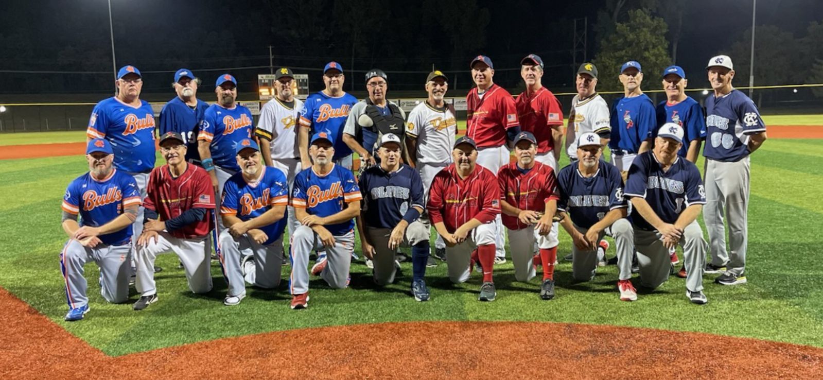 Baseball player sliding into base as another player attempts to catch the ball.
