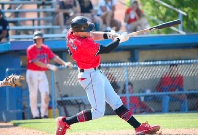 Baseball player sliding into base as another player attempts to catch the ball.