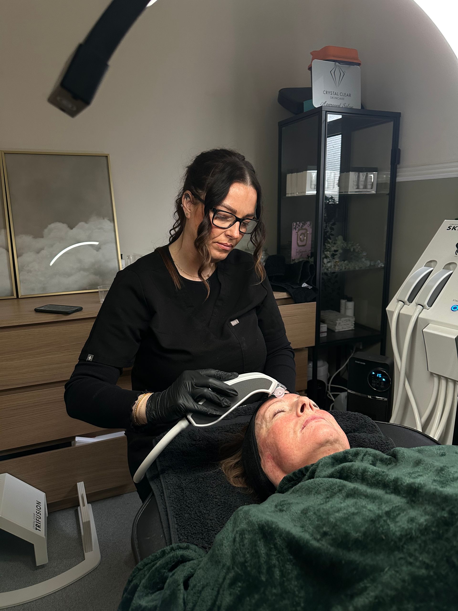 A woman is giving a woman a facial treatment in a salon.