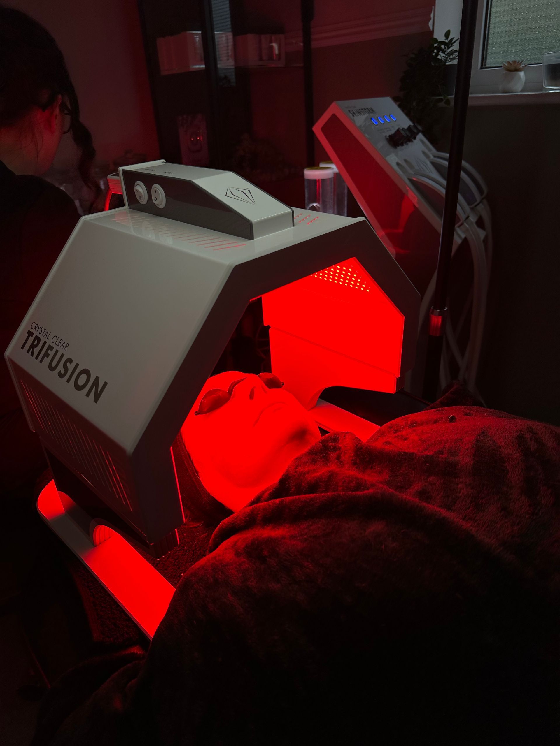 A person is getting a red light treatment on their face