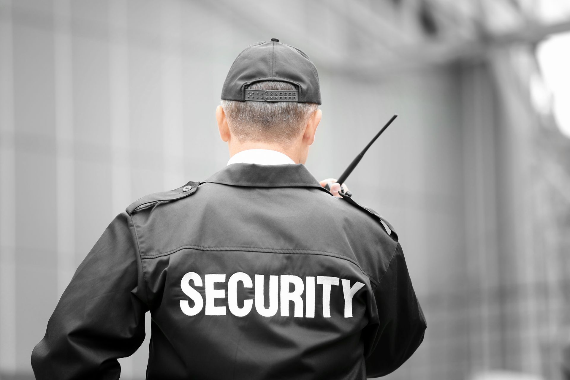 Professional security guard holding a walkie talkie.