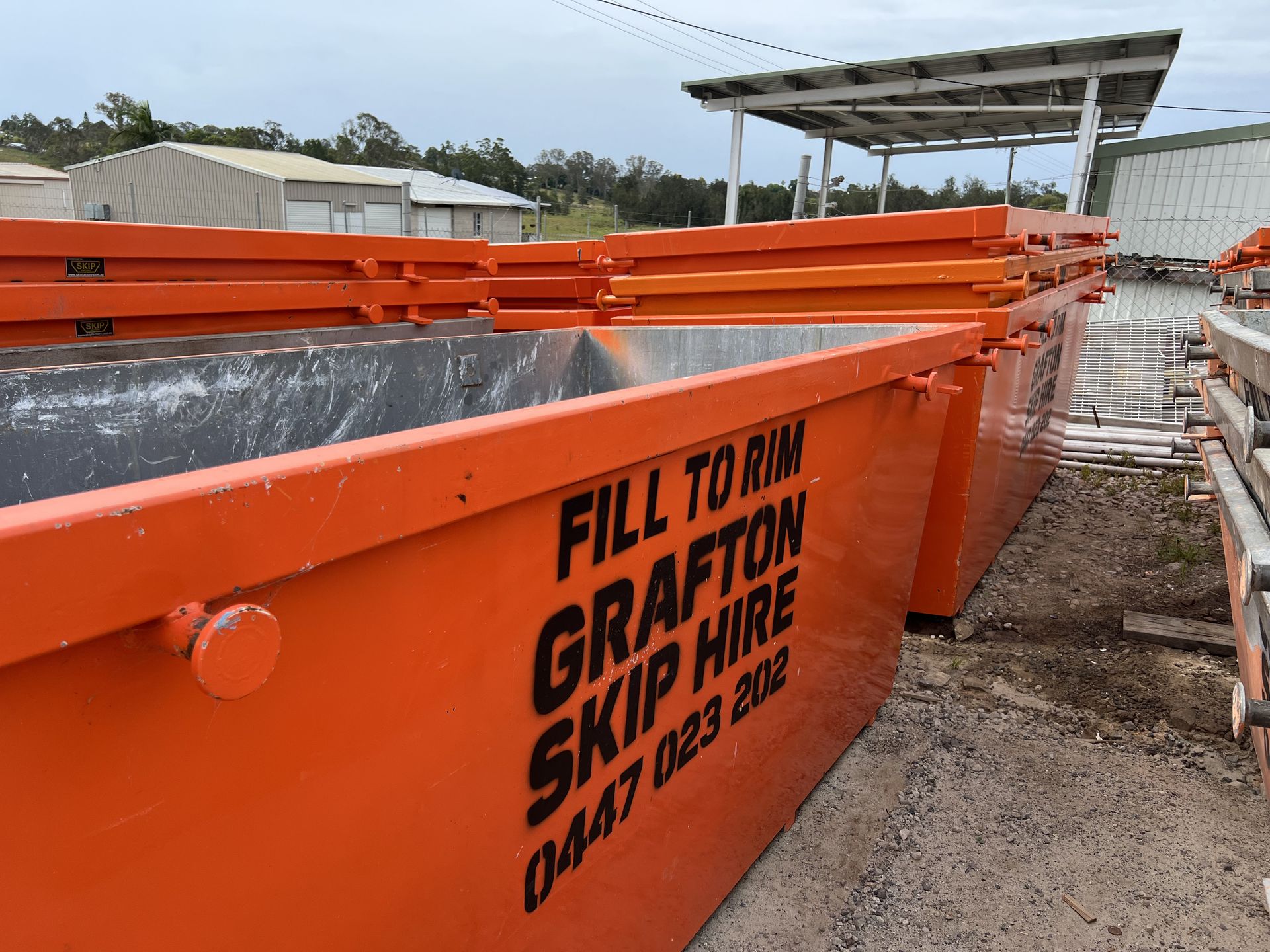 A Green Dumpster is Sitting on the Side of the Road — Grafton Skip Hire–Zims Bins in Coffs Iluka, NSW