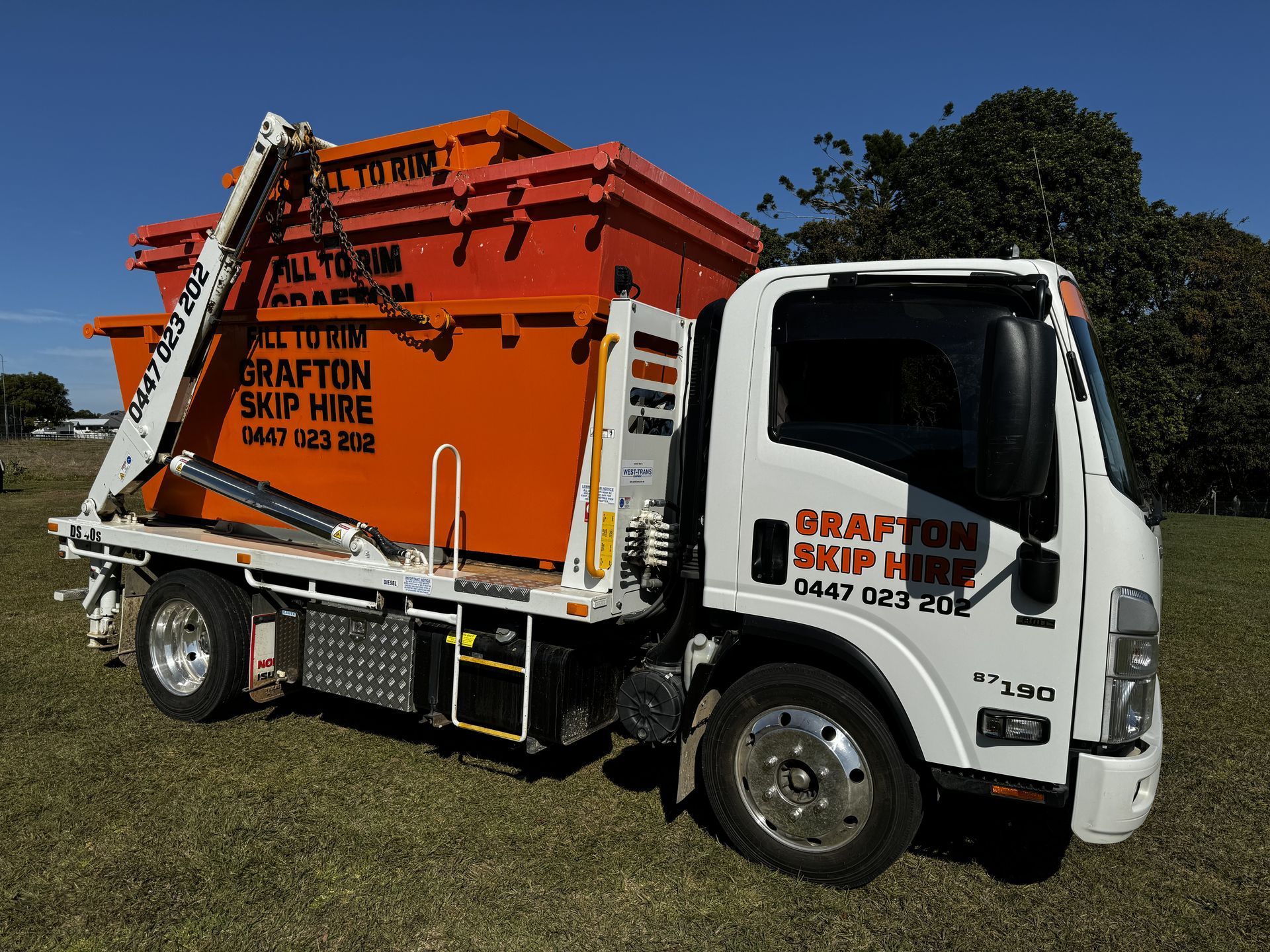 A White Truck With a Purple Dumpster on the Back — Grafton Skip Hire–Zims Bins in South Grafton, NSW
