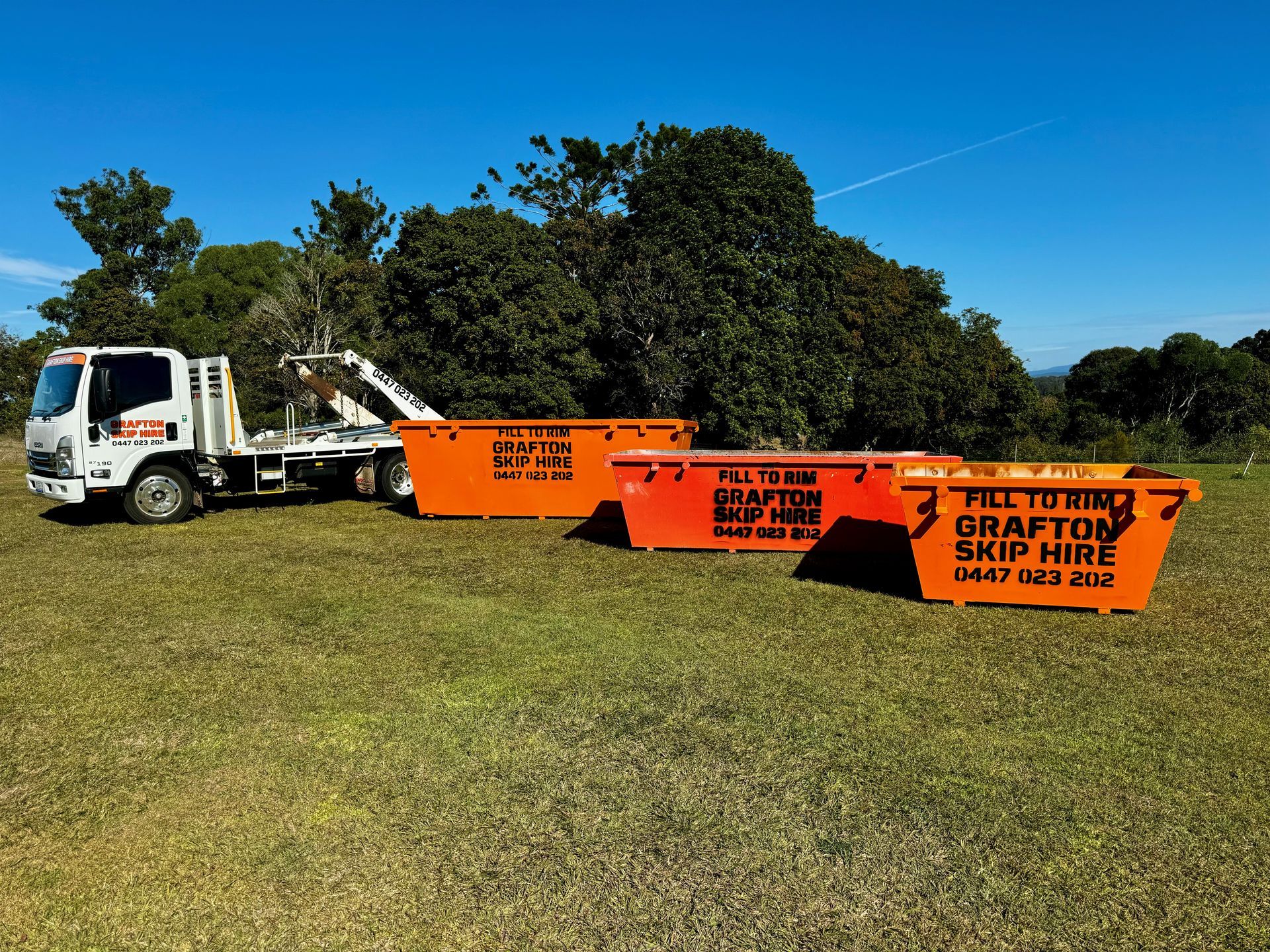 A Yellow Dumpster is Sitting in a Parking Lot in Front of a Building — Grafton Skip Hire–Zims Bins in South Grafton, NSW