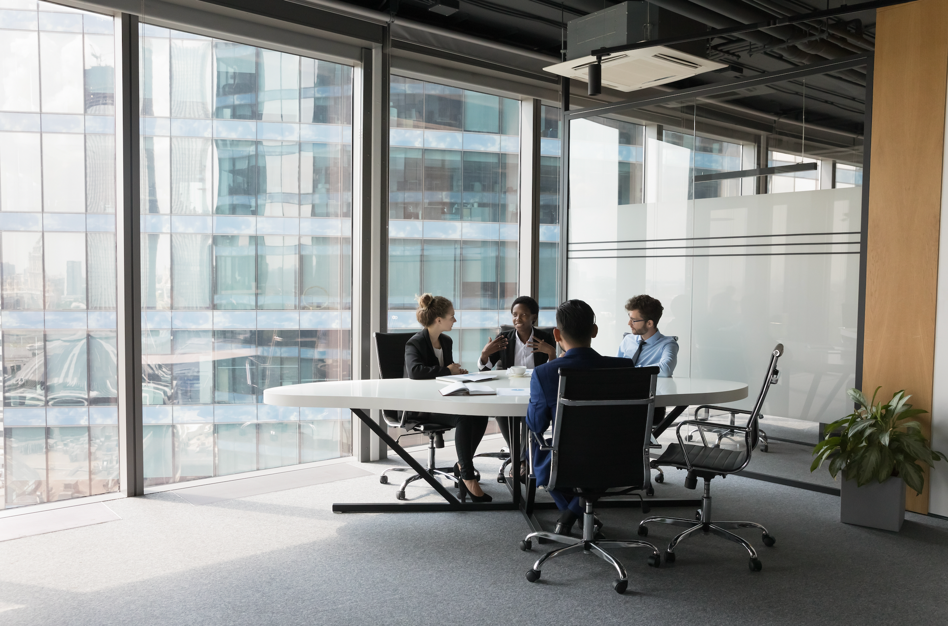 A group of people are sitting around a table in a conference room.