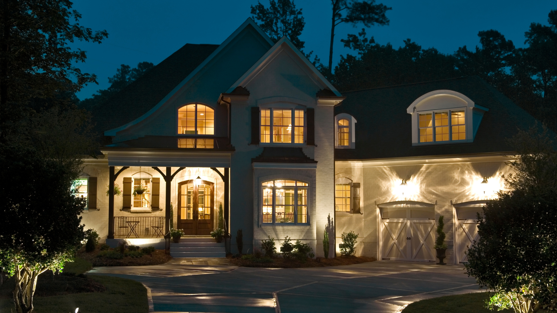 A person wearing gloves uses pliers to install a hanging pendant light fixture to a ceiling junction box.