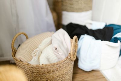 A pile of sweaters stacked on top of each other on a bed.