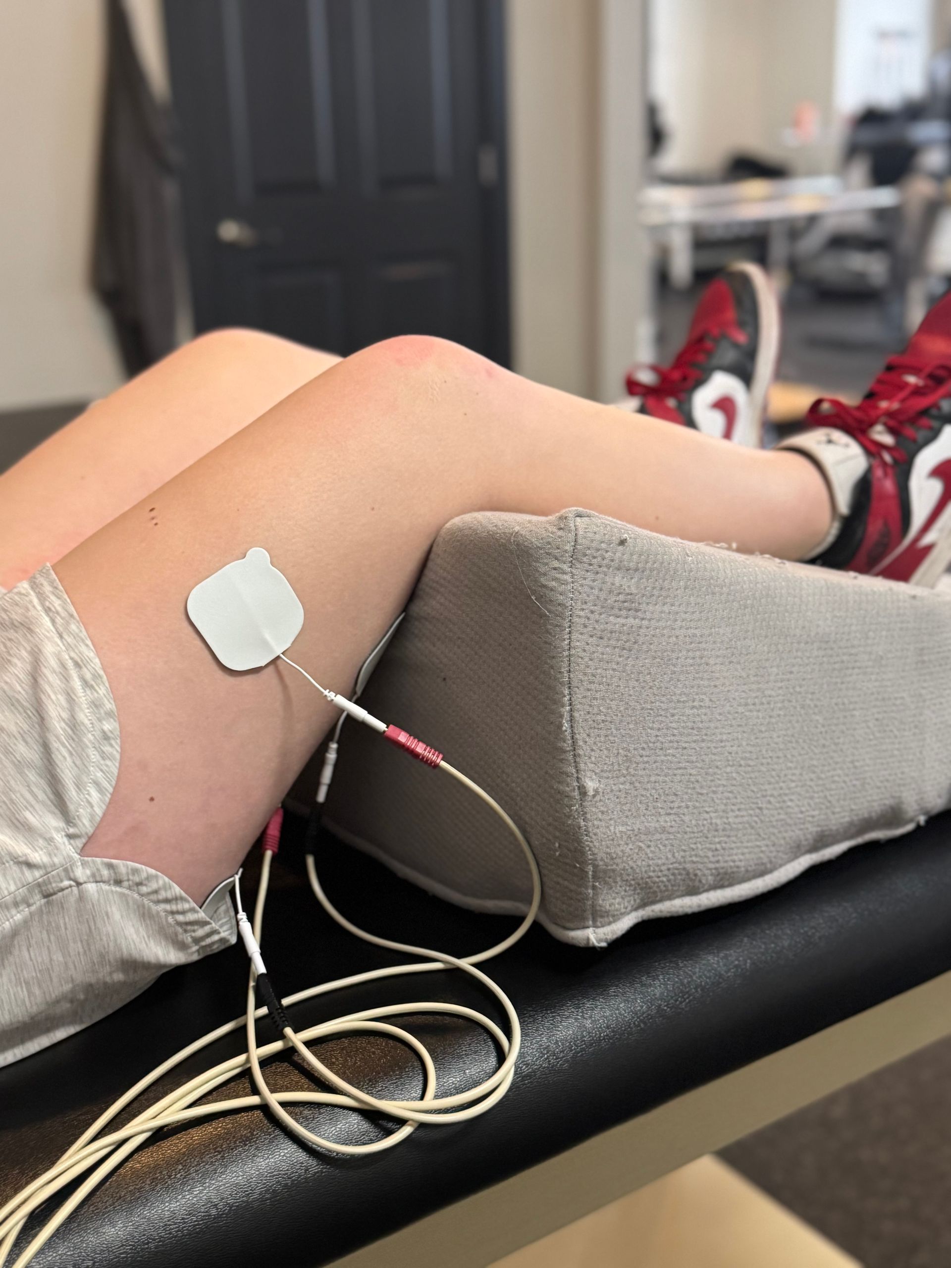 A person is laying on a table with a device on their leg