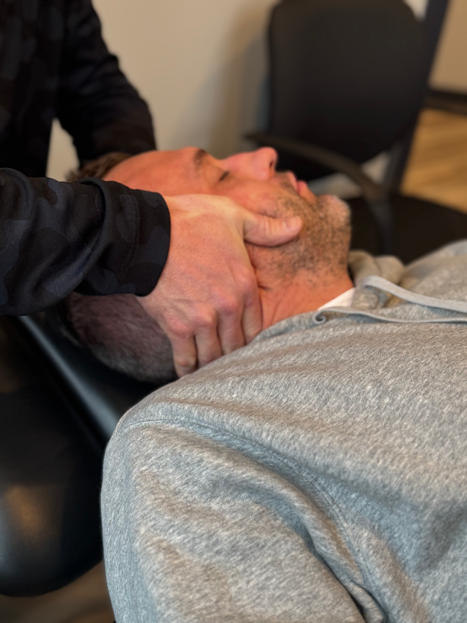 A man is laying on his back getting a massage from a doctor.