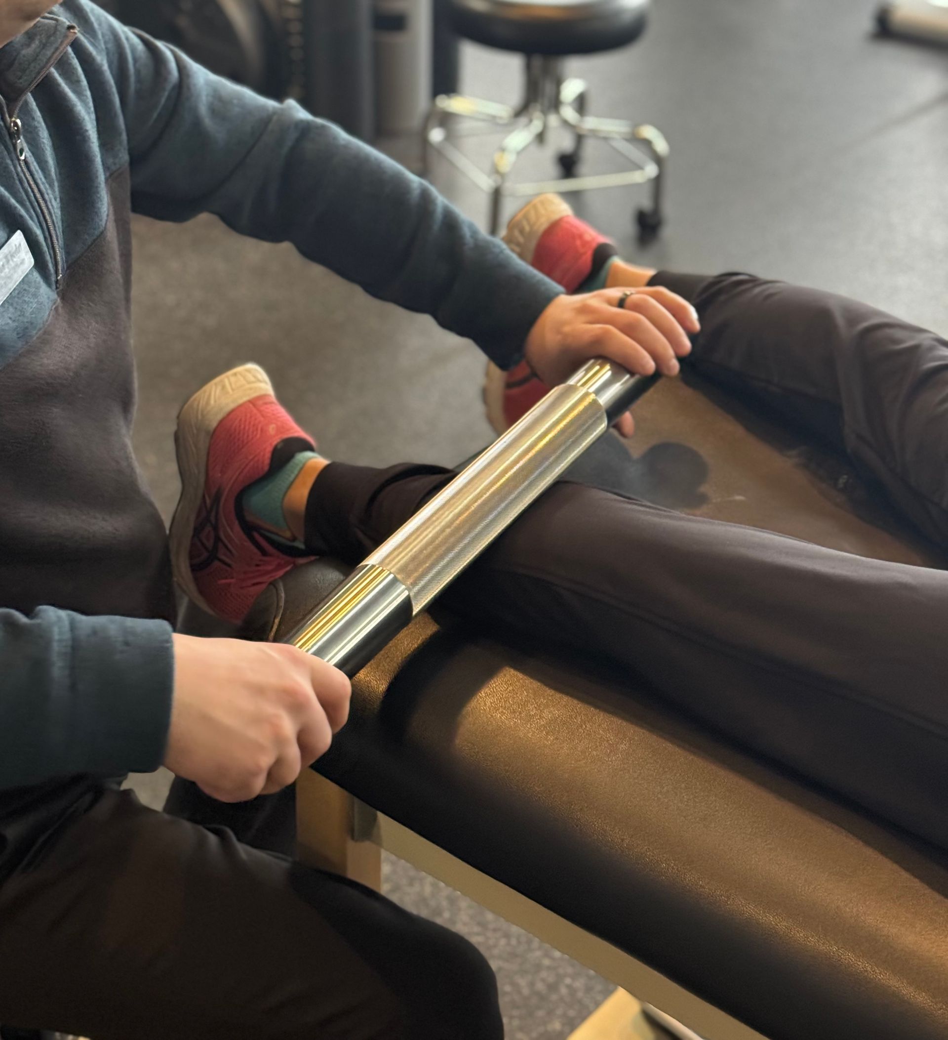 A person is laying on a table with a roller on their leg