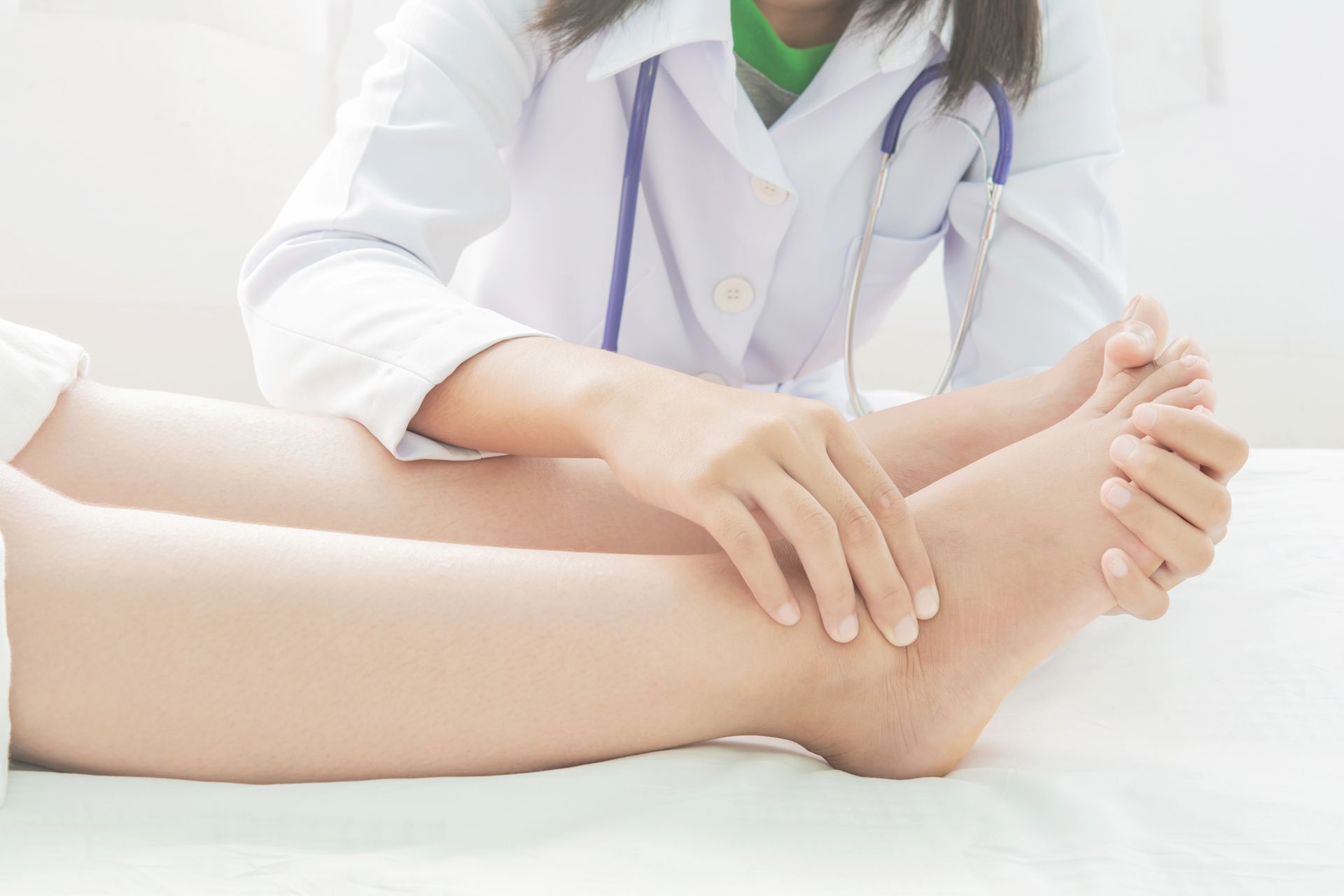 a doctor is examining a patient's leg on a bed, experiencing swelling after an injury