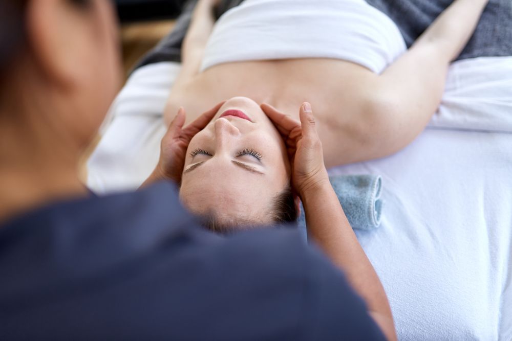 A woman is getting a head massage at a spa.