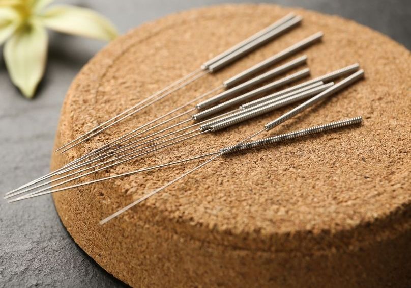 acupuncture needles on a cork coaster