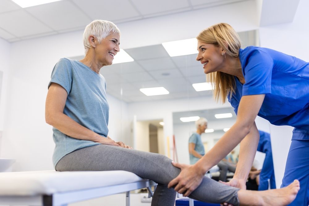 a physical therapist is stretching a patient 's leg.