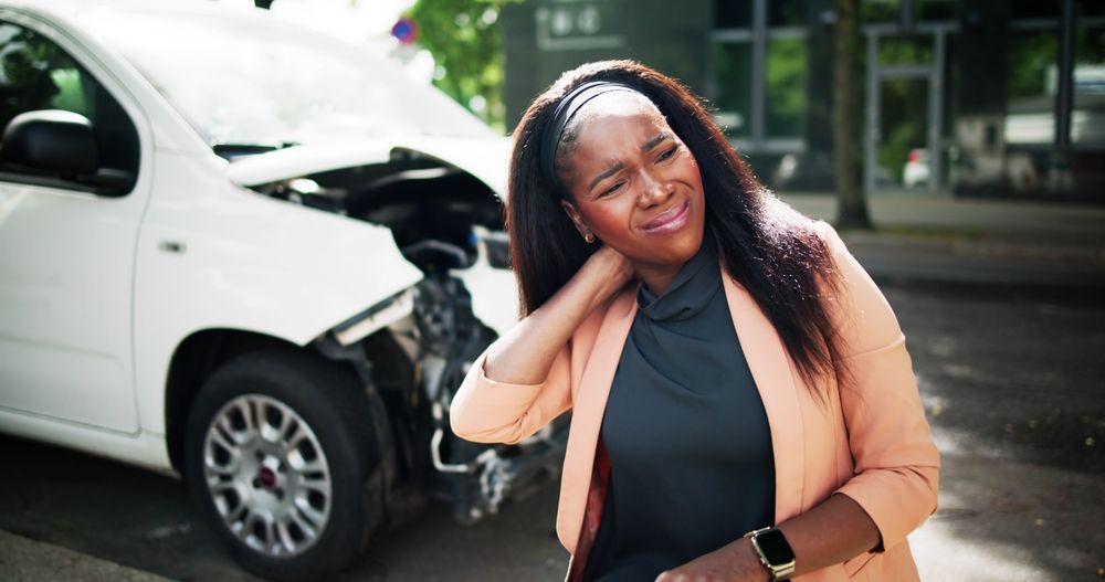 A lady is experiencing neck pain from a car accident.