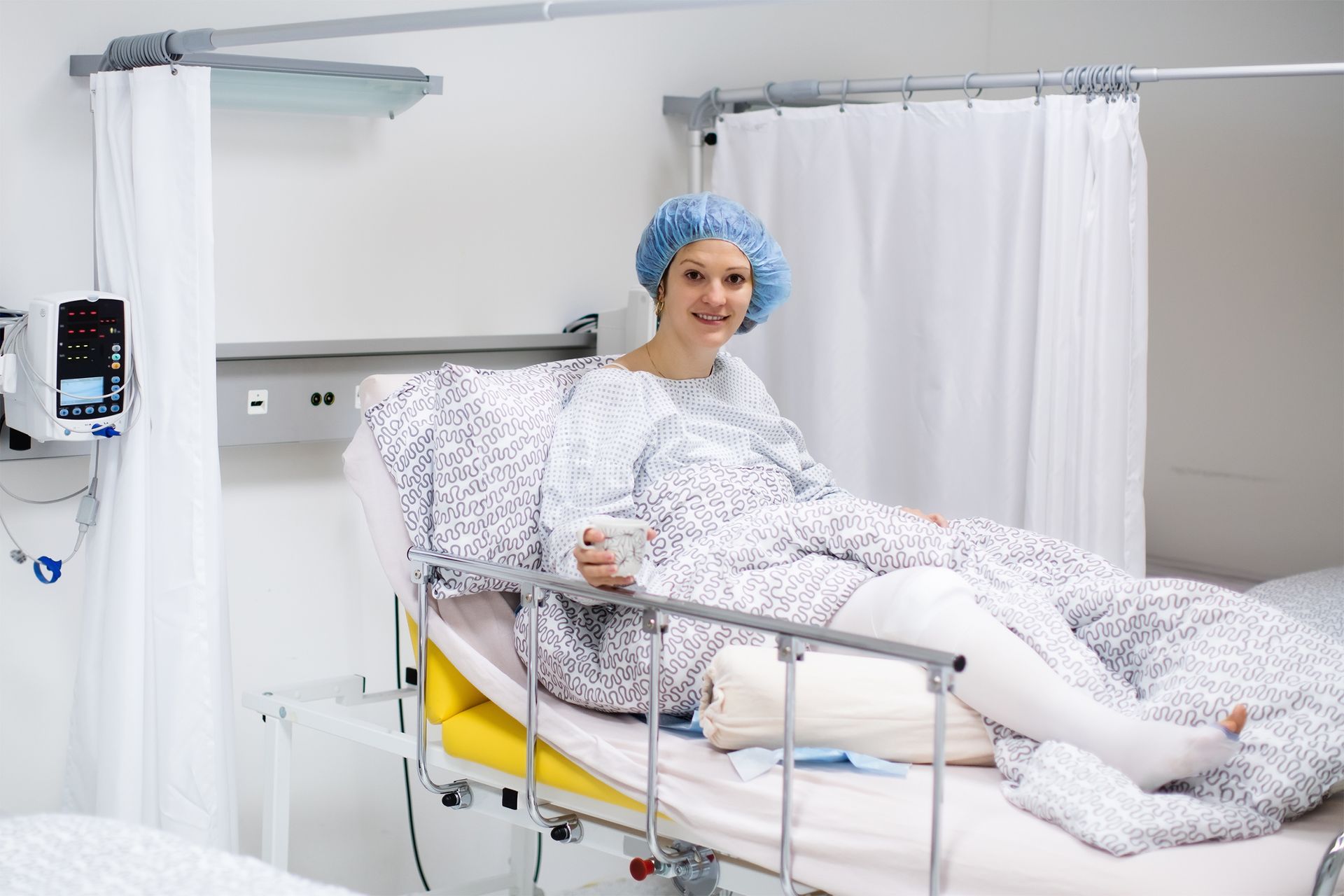 a woman is laying in a hospital bed with a bandaged leg, experiencing swelling after an injury