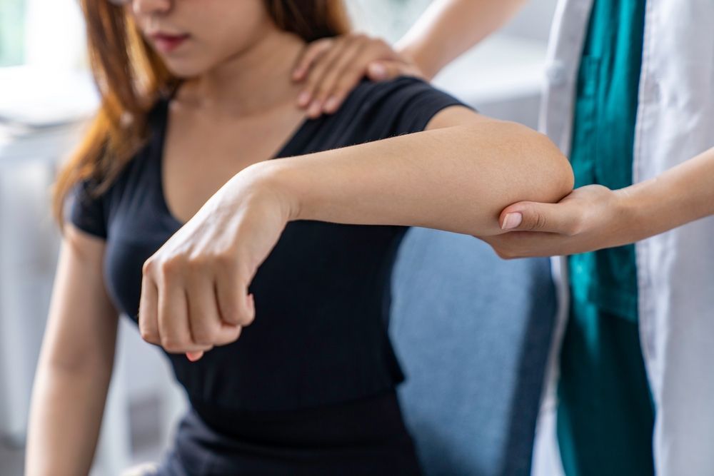 A woman is getting her arm examined by a doctor.