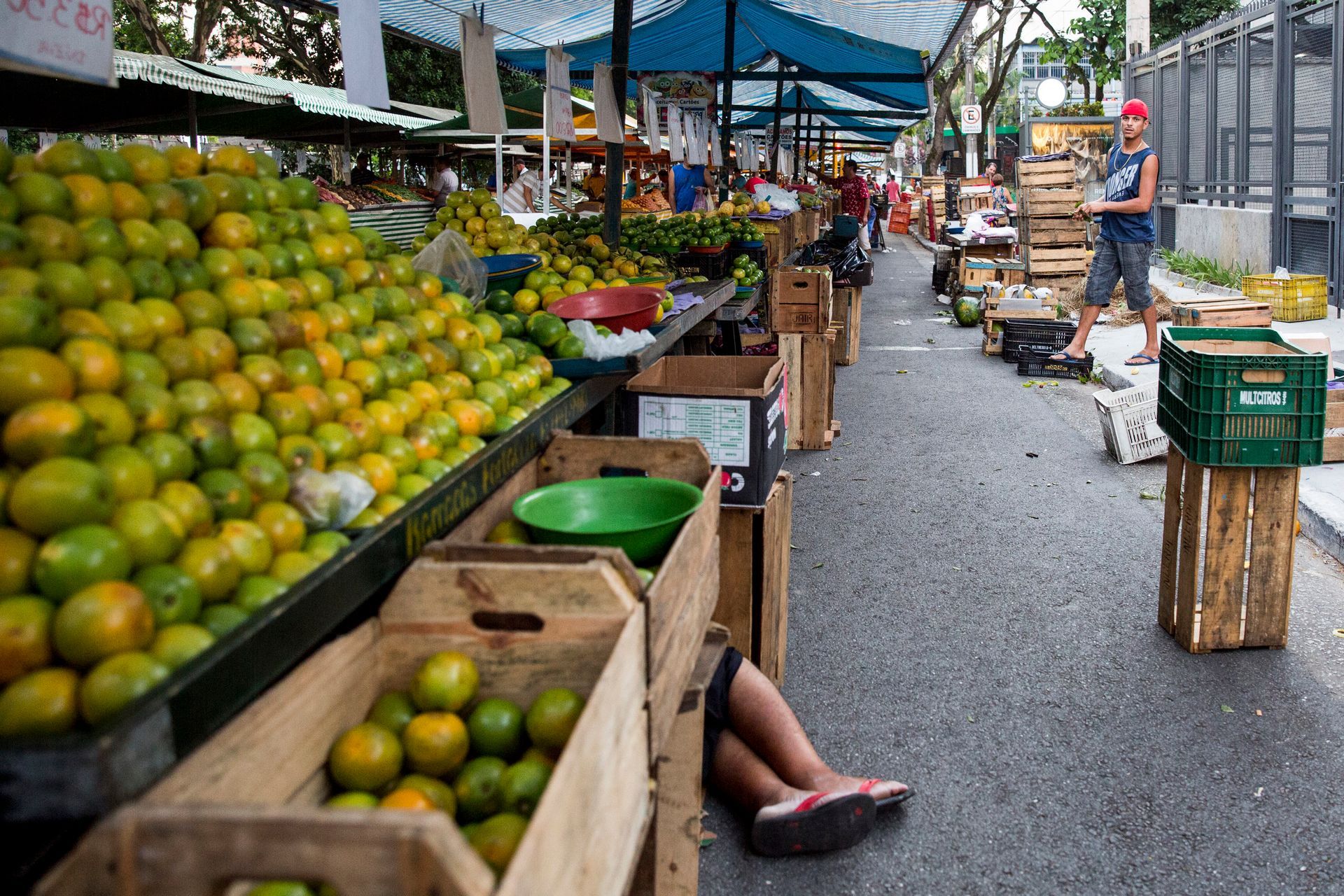Fotografia autoral de feira livre em São Paulo — detalhe de barraca e dormindo