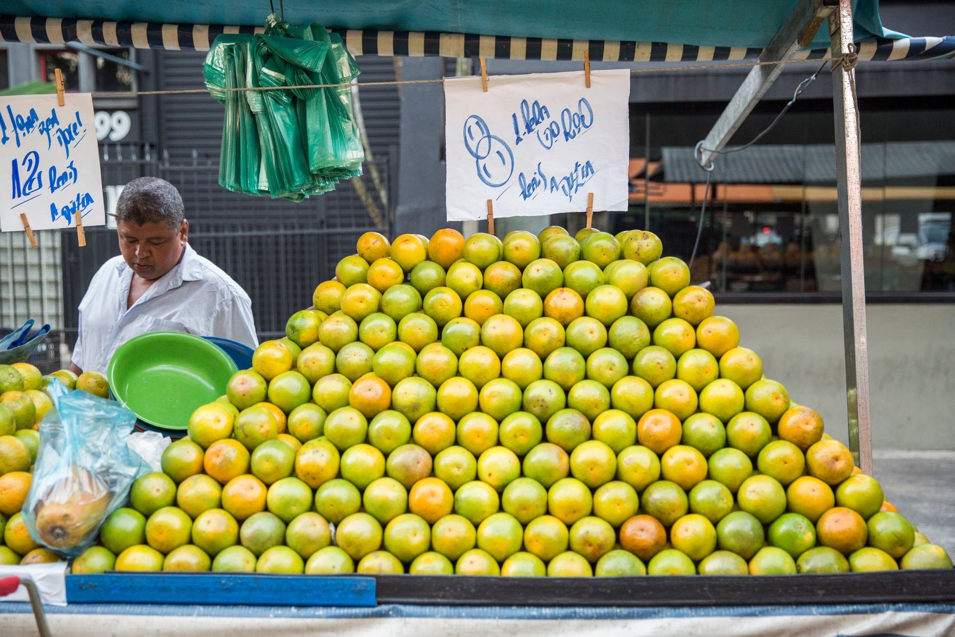 Fotografia autoral de feira livre em São Paulo — detalhe de barraca laranja