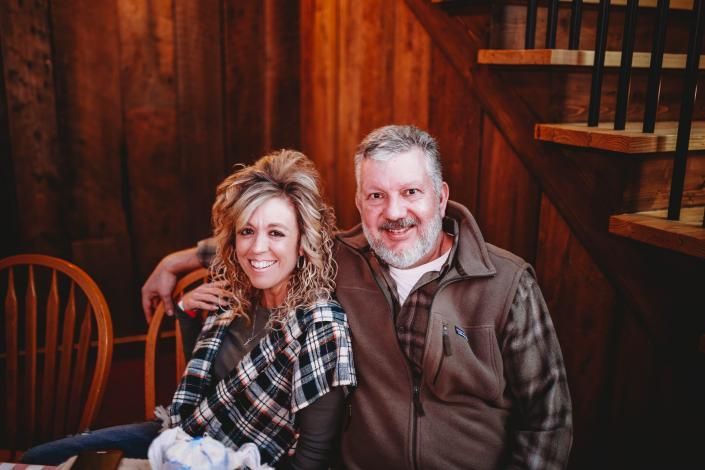 Two smiling people seated together in a warm wooden interior