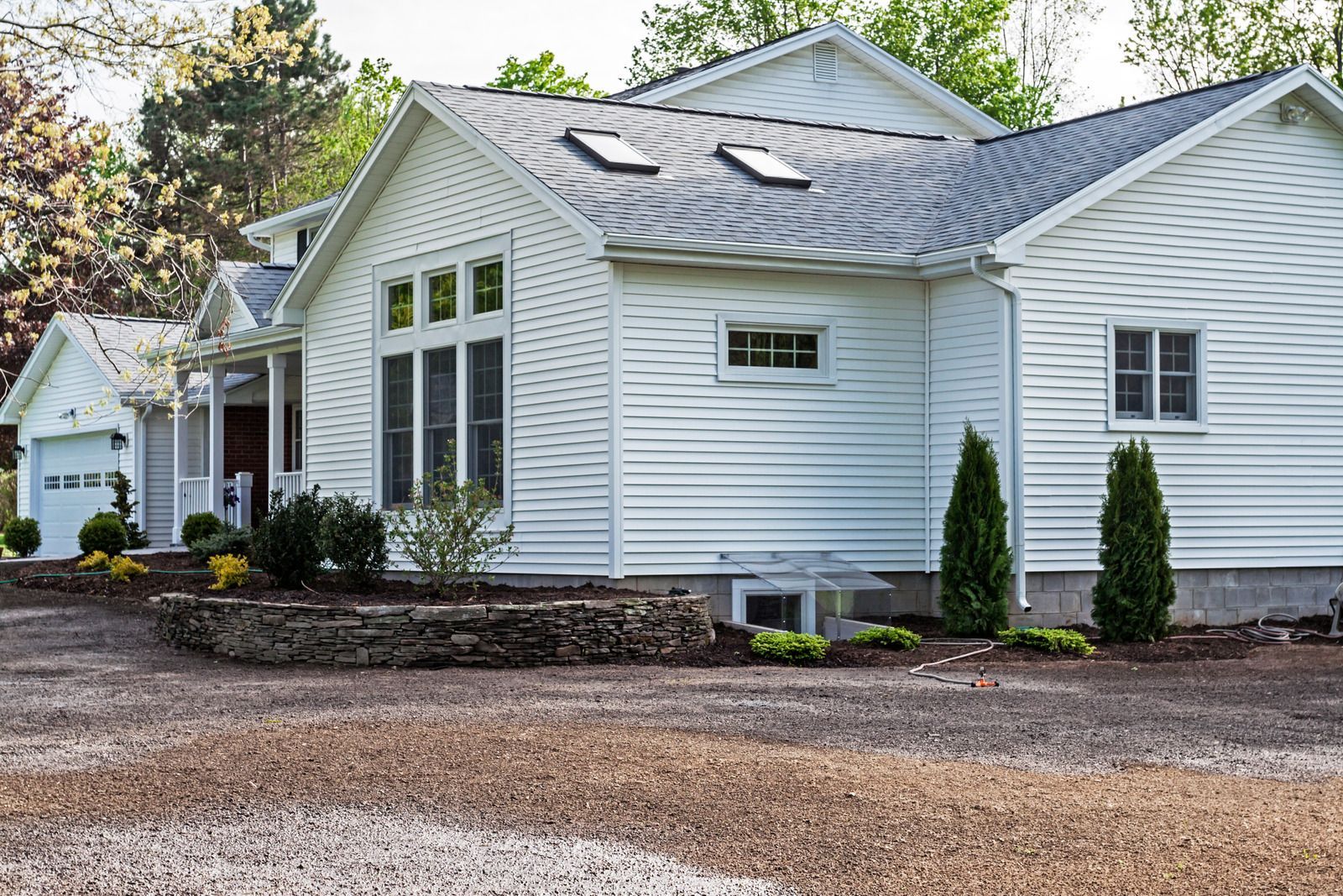 A white house with a gray roof and a lot of windows
