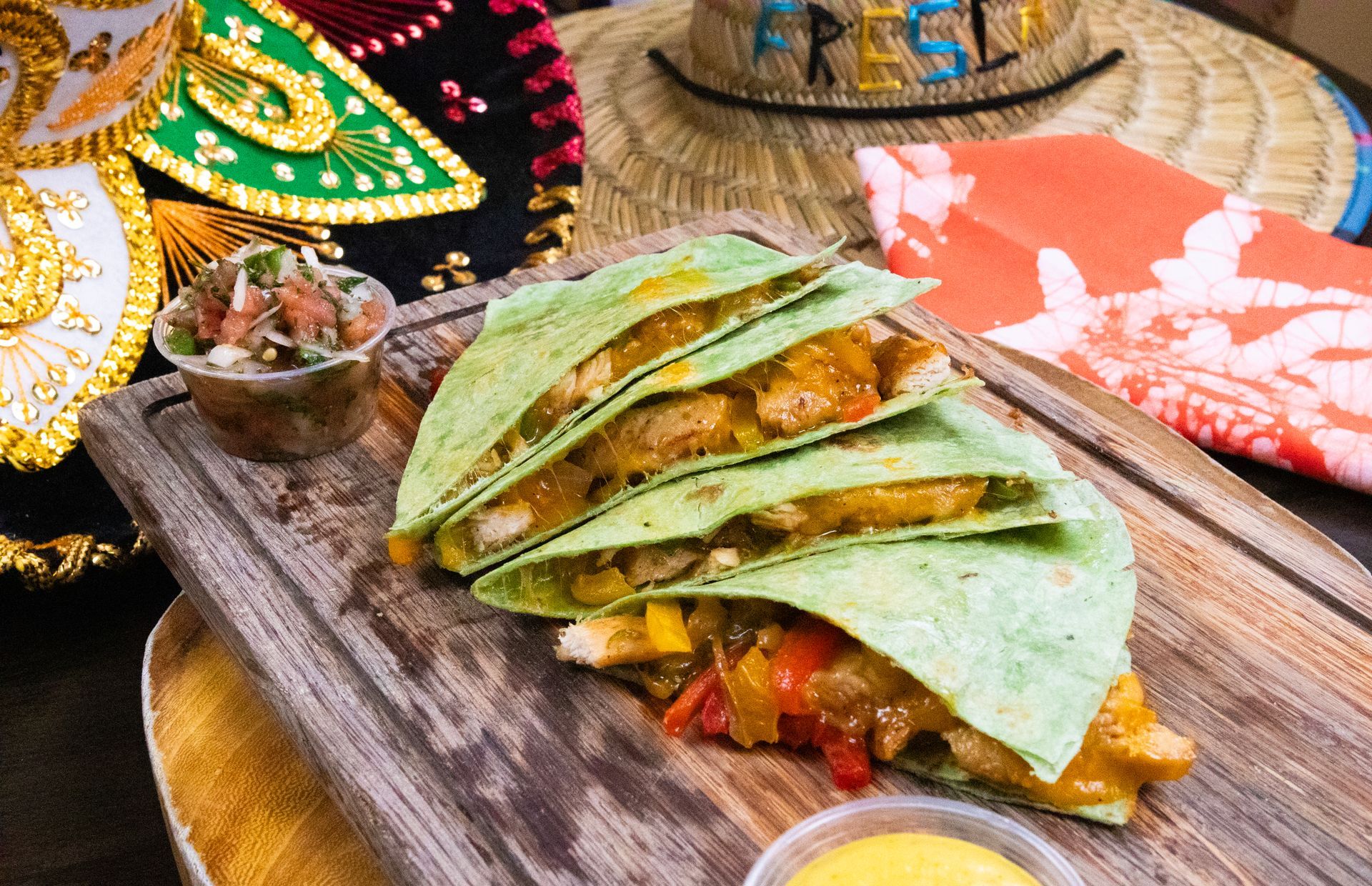 A quesadilla is sitting on top of a wooden cutting board.