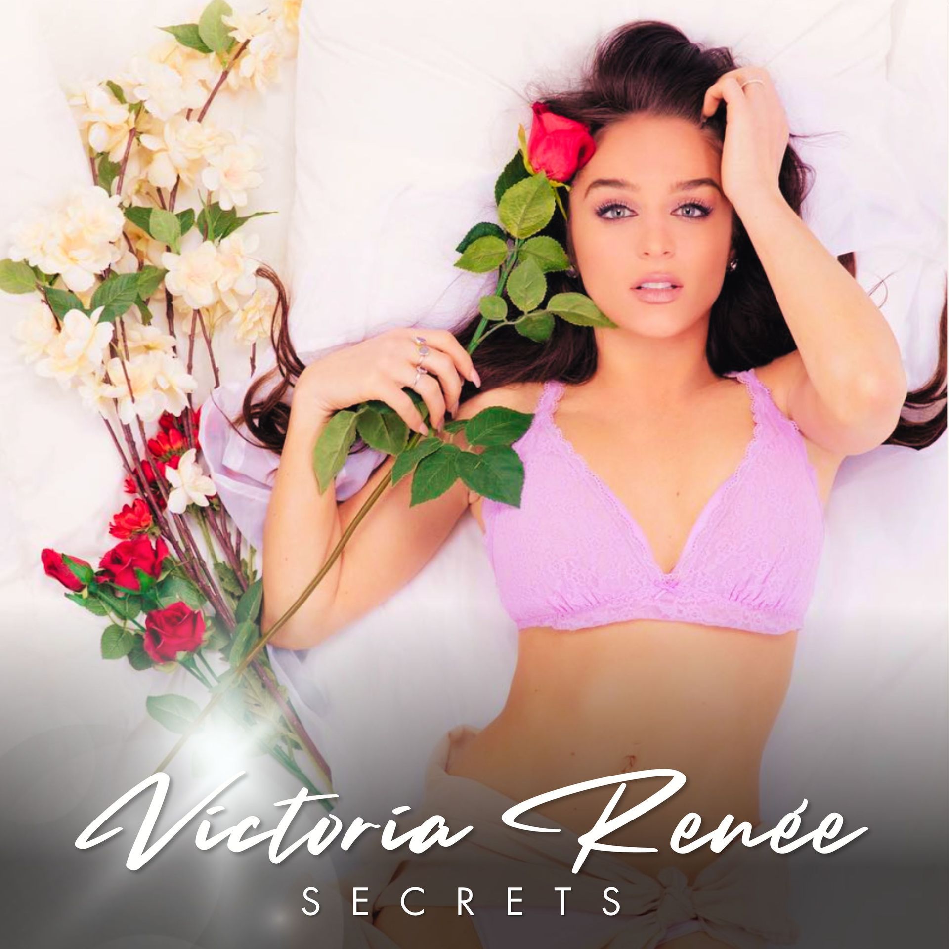 Victoria renee is laying on a bed holding a rose