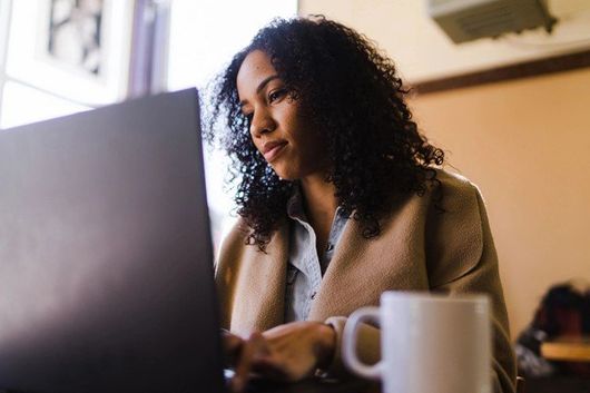 woman helping child on computer