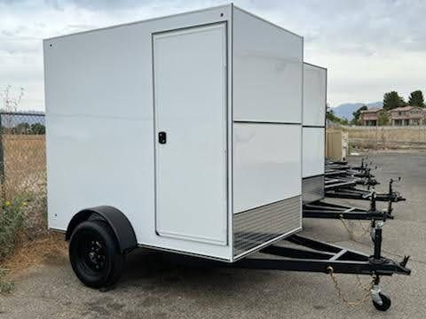 Parked Short White Enclosed Trailers Side View