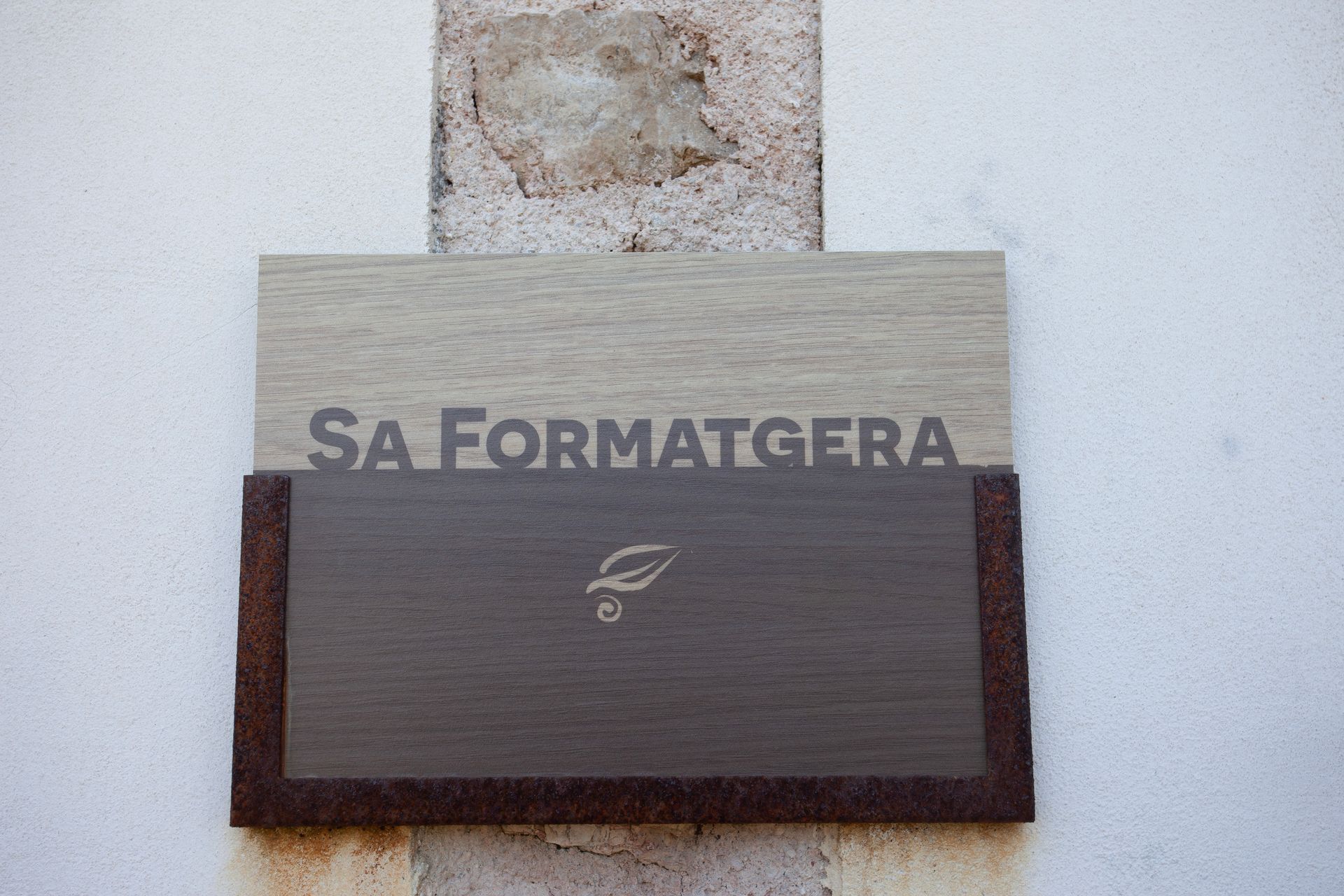 Ein Schild an einer Wand mit der Aufschrift „Sa formatgera“