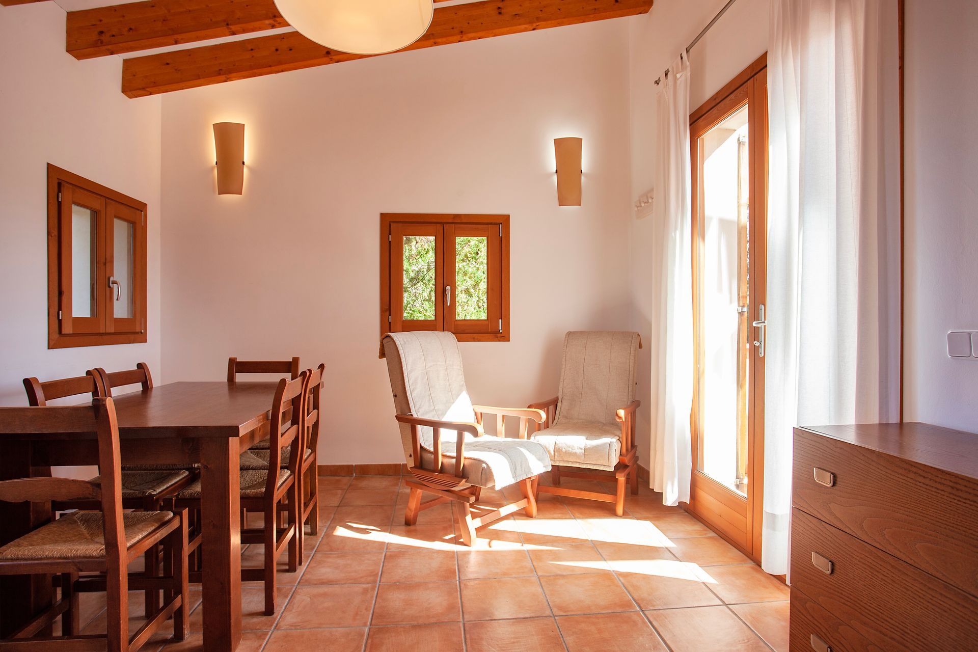 Ein Wohnzimmer mit Tisch und Stühlen und einem Fenster